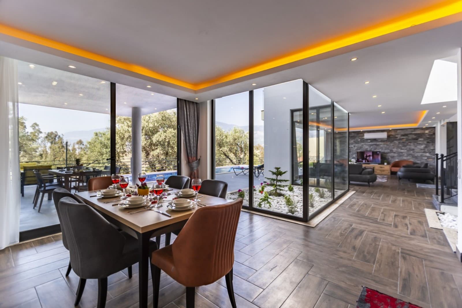 Yemek masası ve cam bölmeli iç bahçesi olan geniş salon