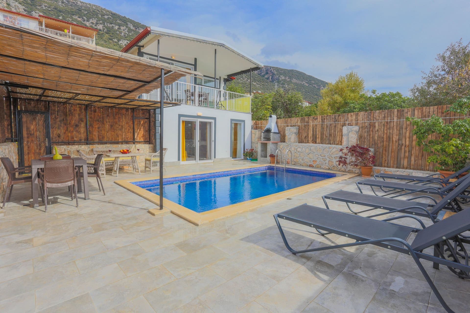 Bahçesinde havuz ve şezlonglar olan iki katlı villa