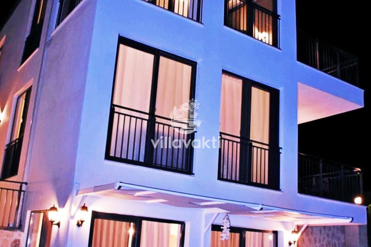 Aydınlatmalı beyaz villanın dış cephesi gece görünümü