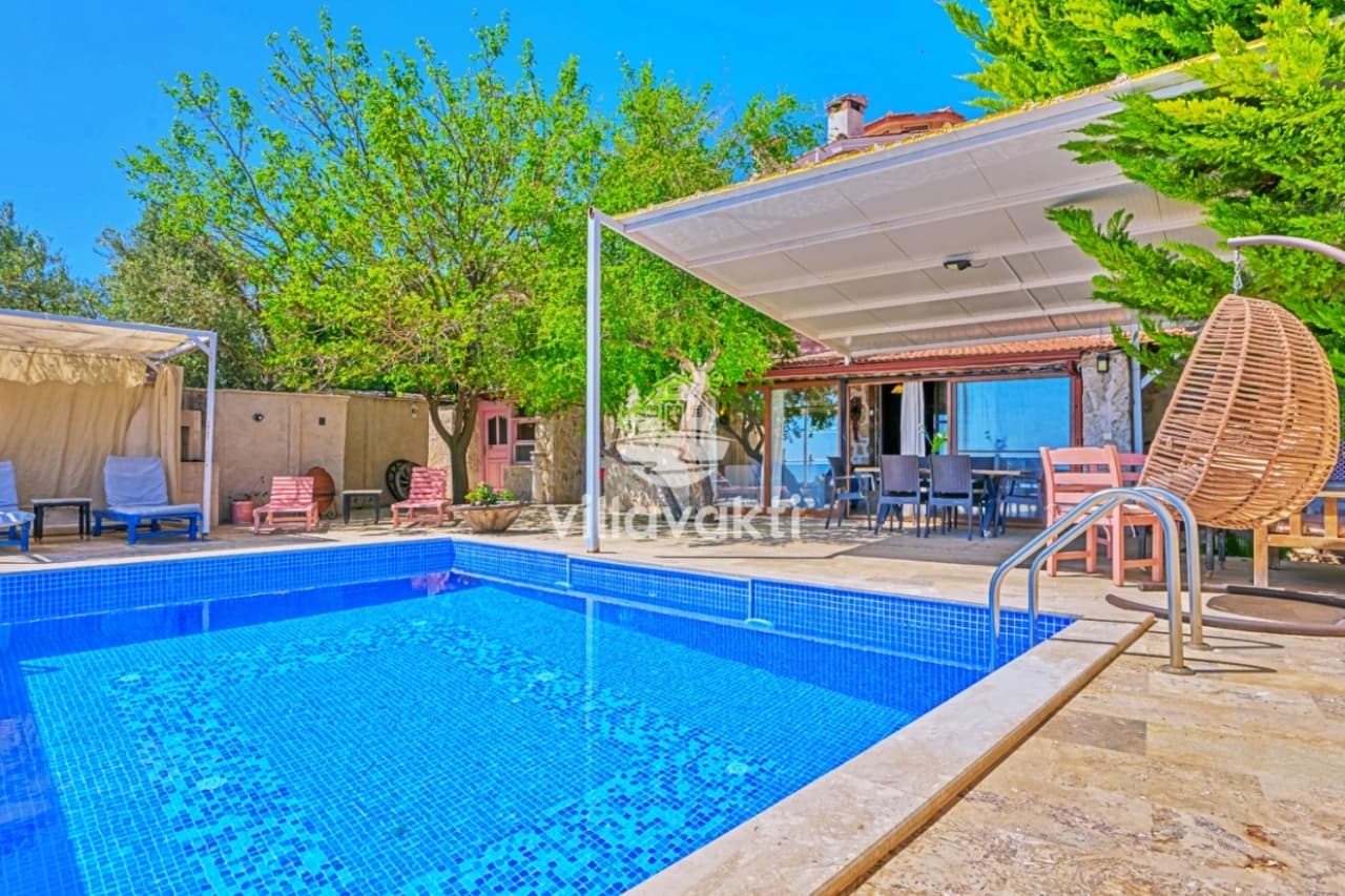 Bahçesindeki yüzme havuzu ve salıncak olan villa dış cephesi.