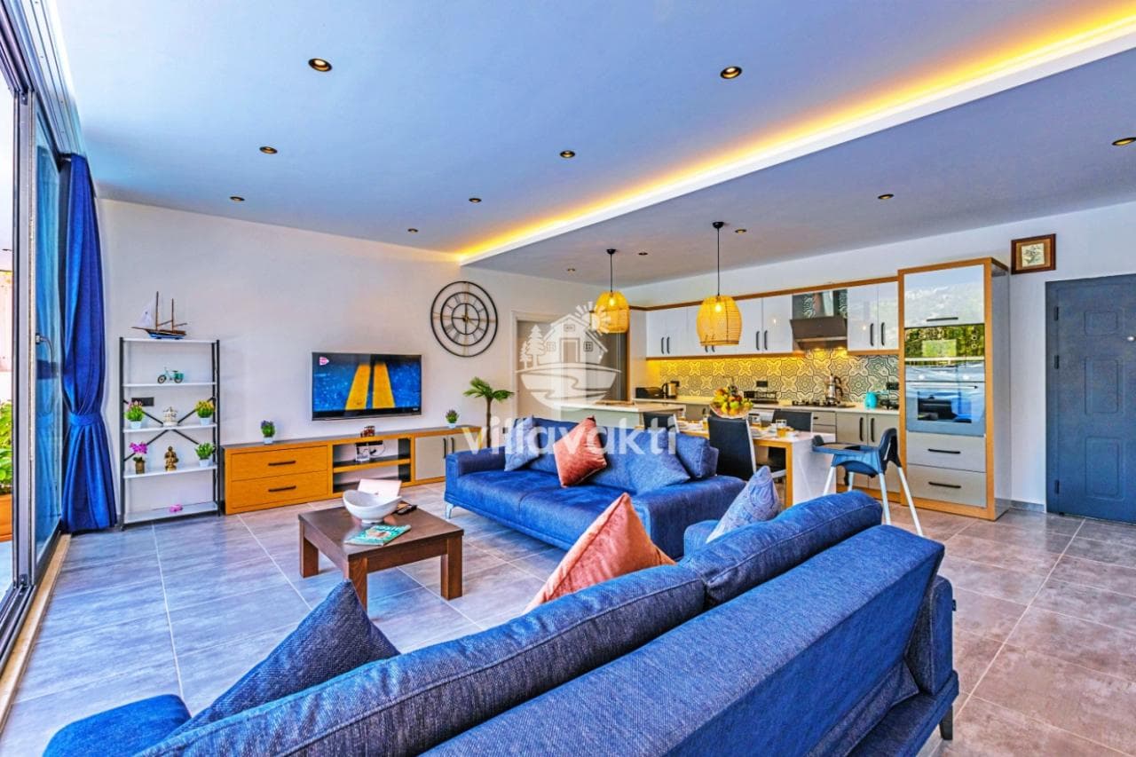 Mavi koltuklar, ahşap sehpa ve açık mutfaklı modern oturma odası.