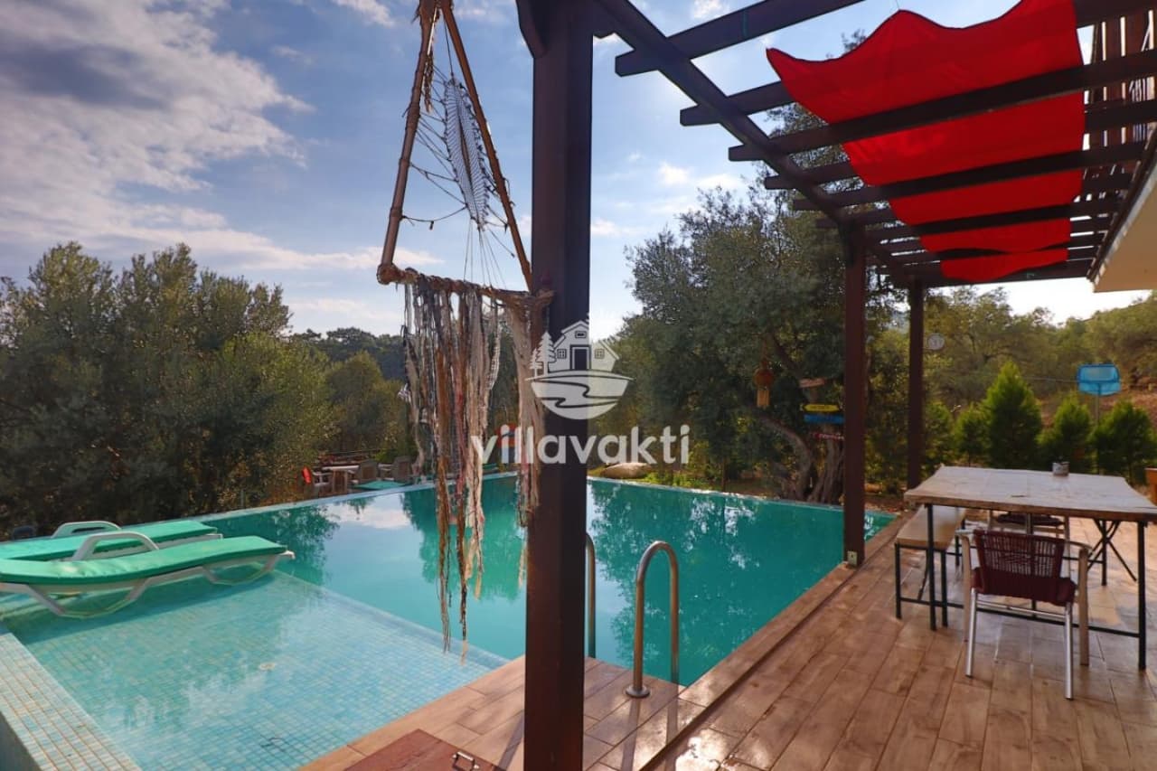 Ahşap pergola altında havuz ve şezlonglar