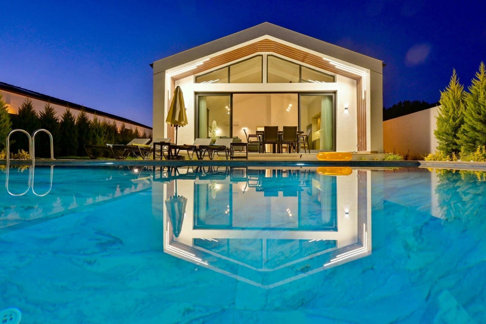 Akşam aydınlatmalı villanın havuzdaki yansıması.