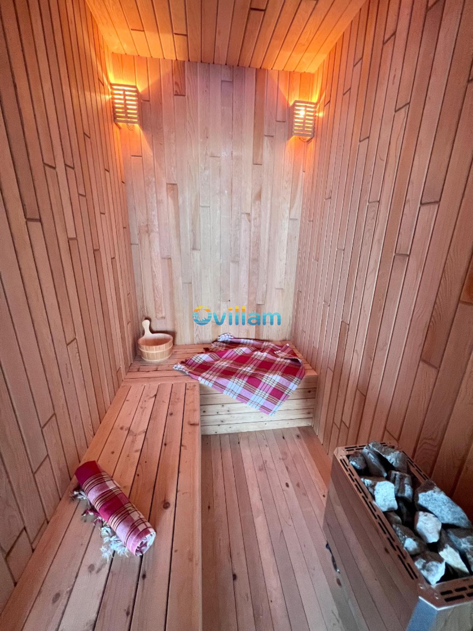 Ahşap duvarlı ve oturma alanlı sauna odası.