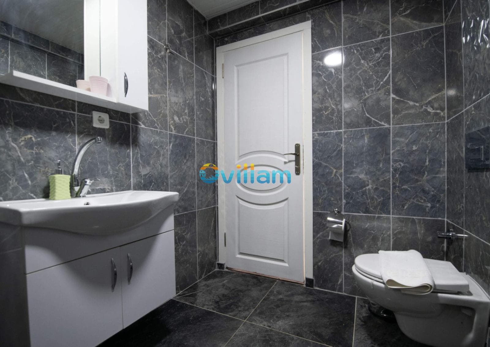 Gri mermer kaplı duvarları olan modern banyo ve lavabo.