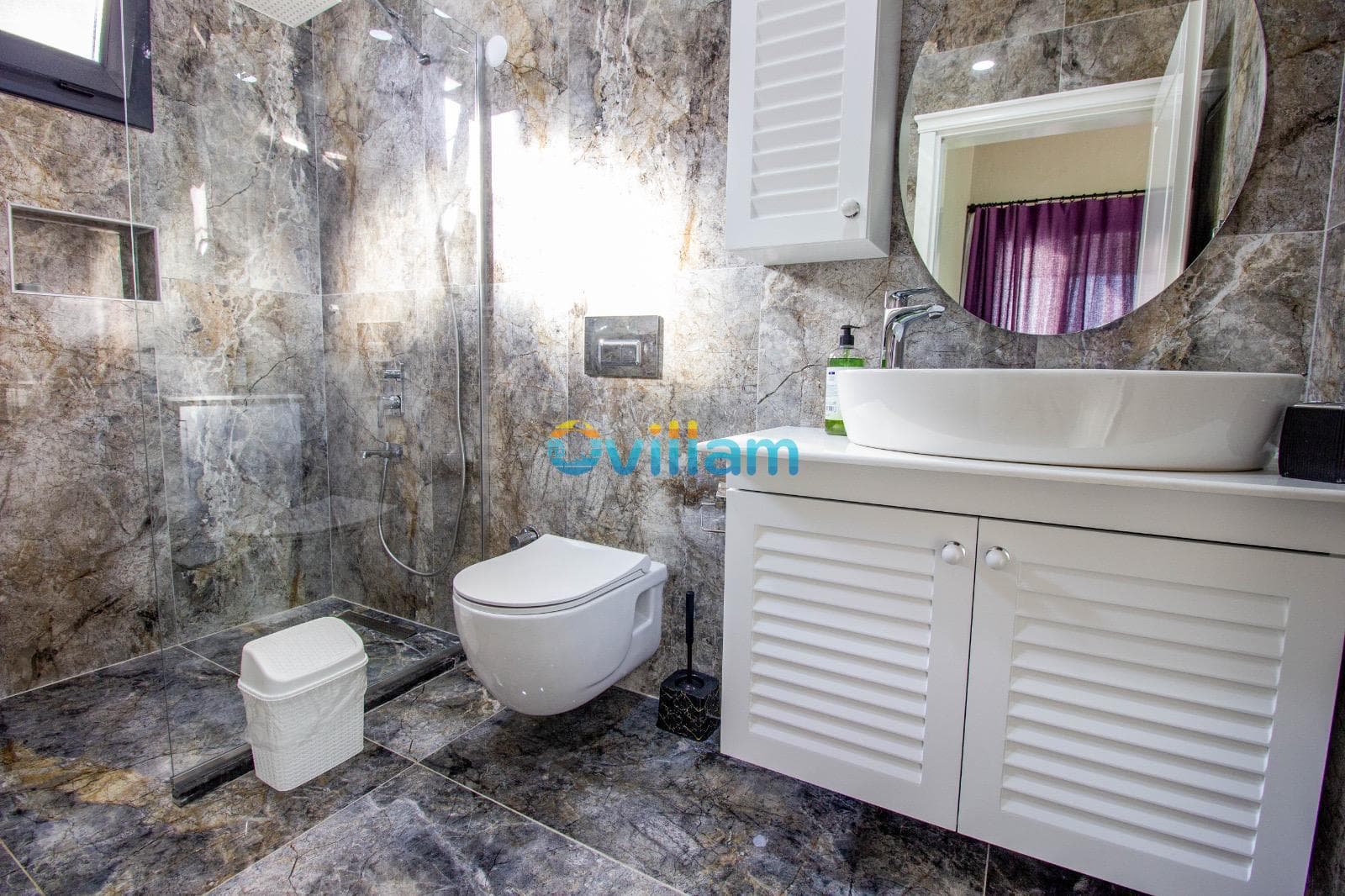 Mermer kaplı duvarları olan modern banyo ve duşakabin.