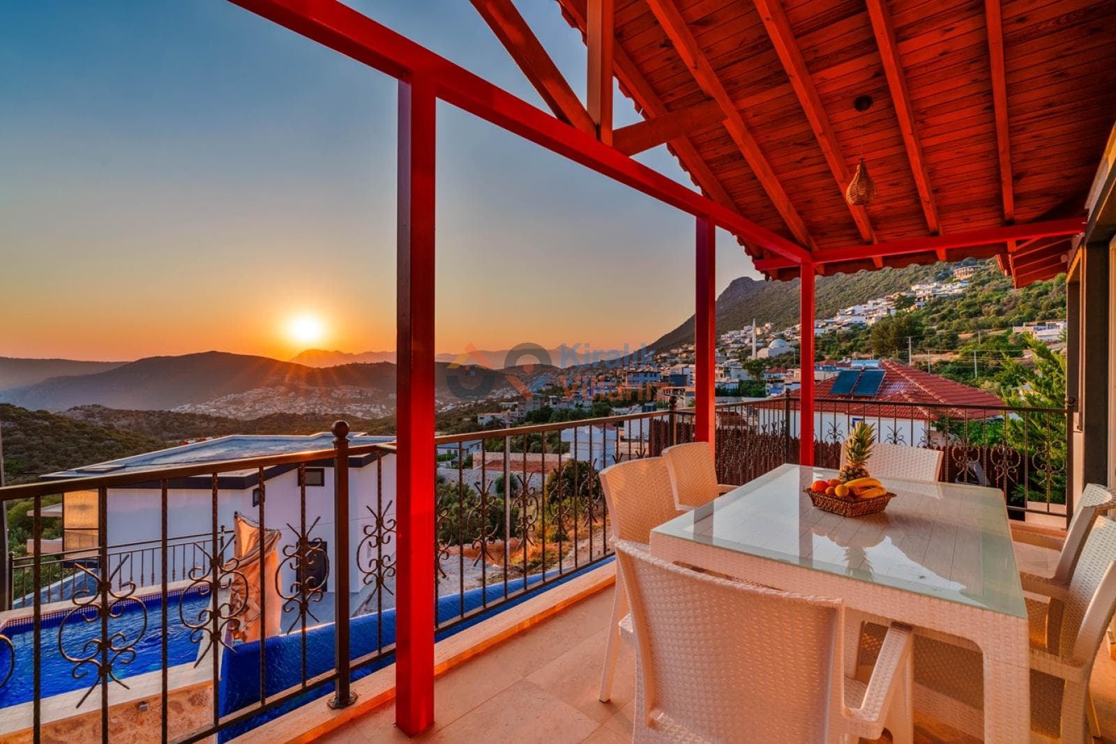 Gün batımı manzarasında balkon ve yemek masası.