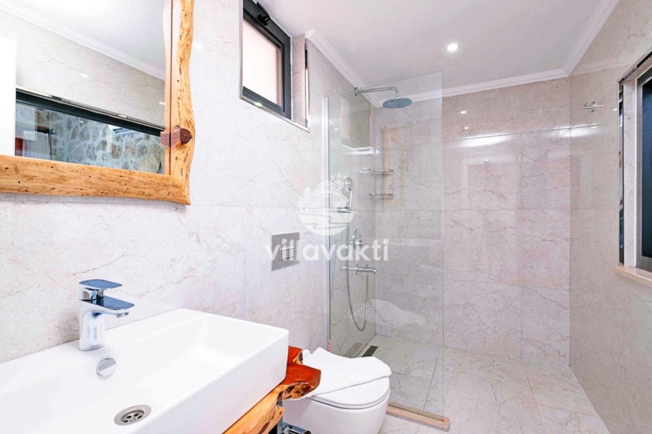 Mermer kaplı duş alanına sahip modern banyo.