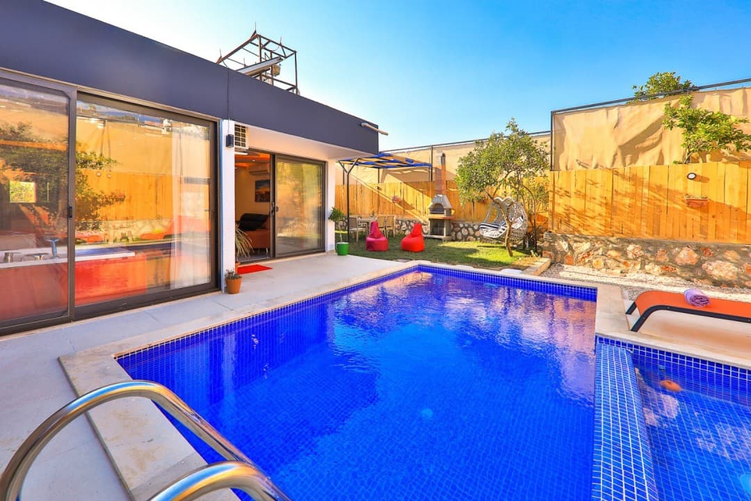 Mavi fayanslı havuzu, bahçesinde salıncağı, barbeküsü ve oturma alanı bulunan modern villa dış görünümü.