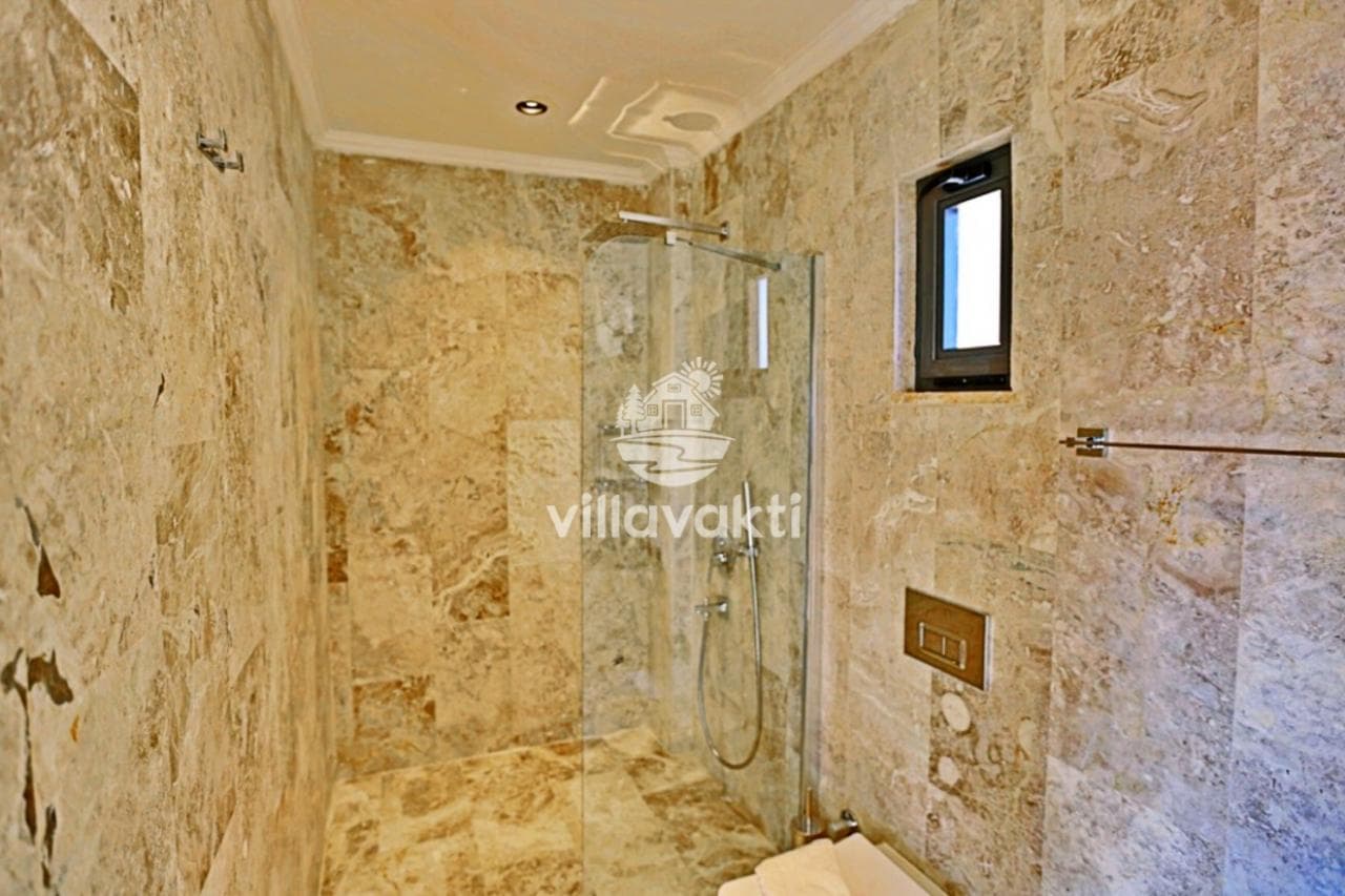 Bej mermer kaplı duş alanına sahip modern banyo.