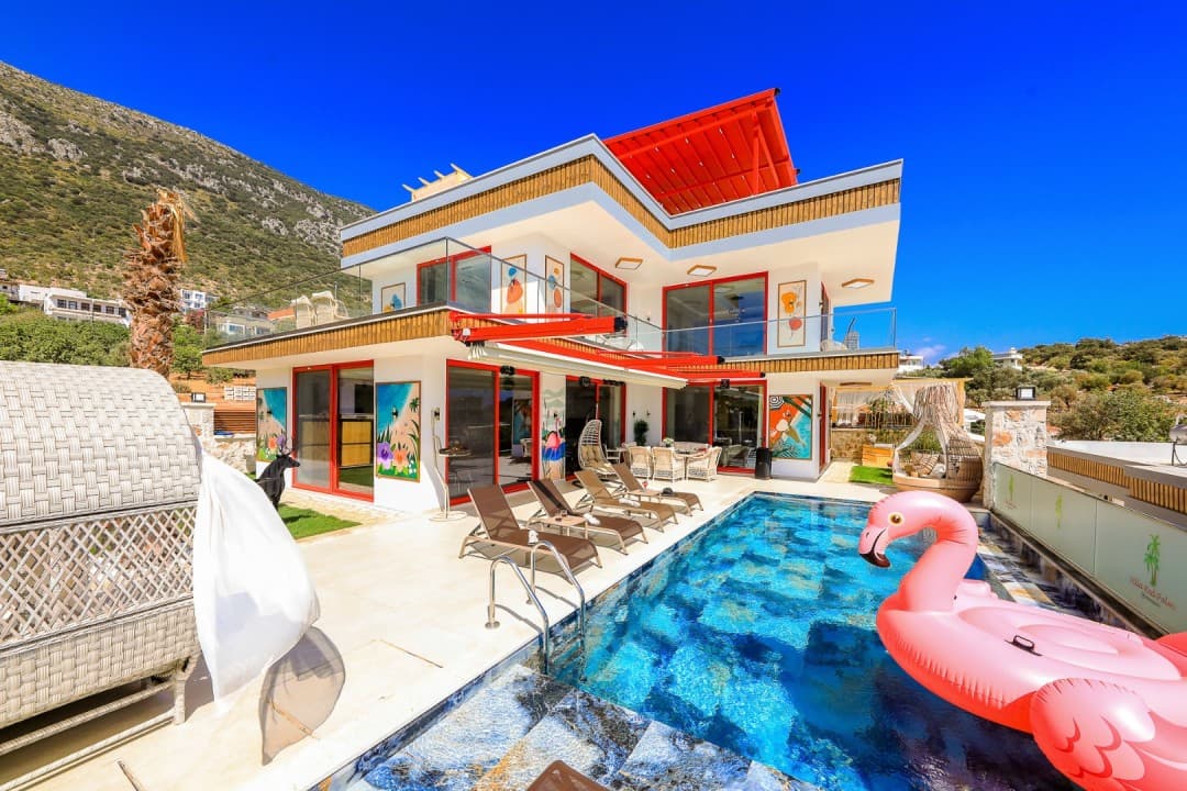 Havuzlu ve şezlonglu lüks villanın dış cephesi ile pembe flamingo deniz yatağı.