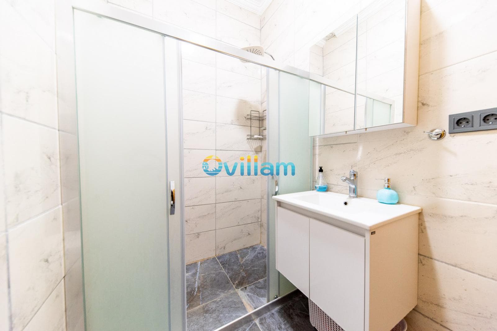 Beyaz banyo dolabı, lavabo, aynalı dolap ve duşakabin.