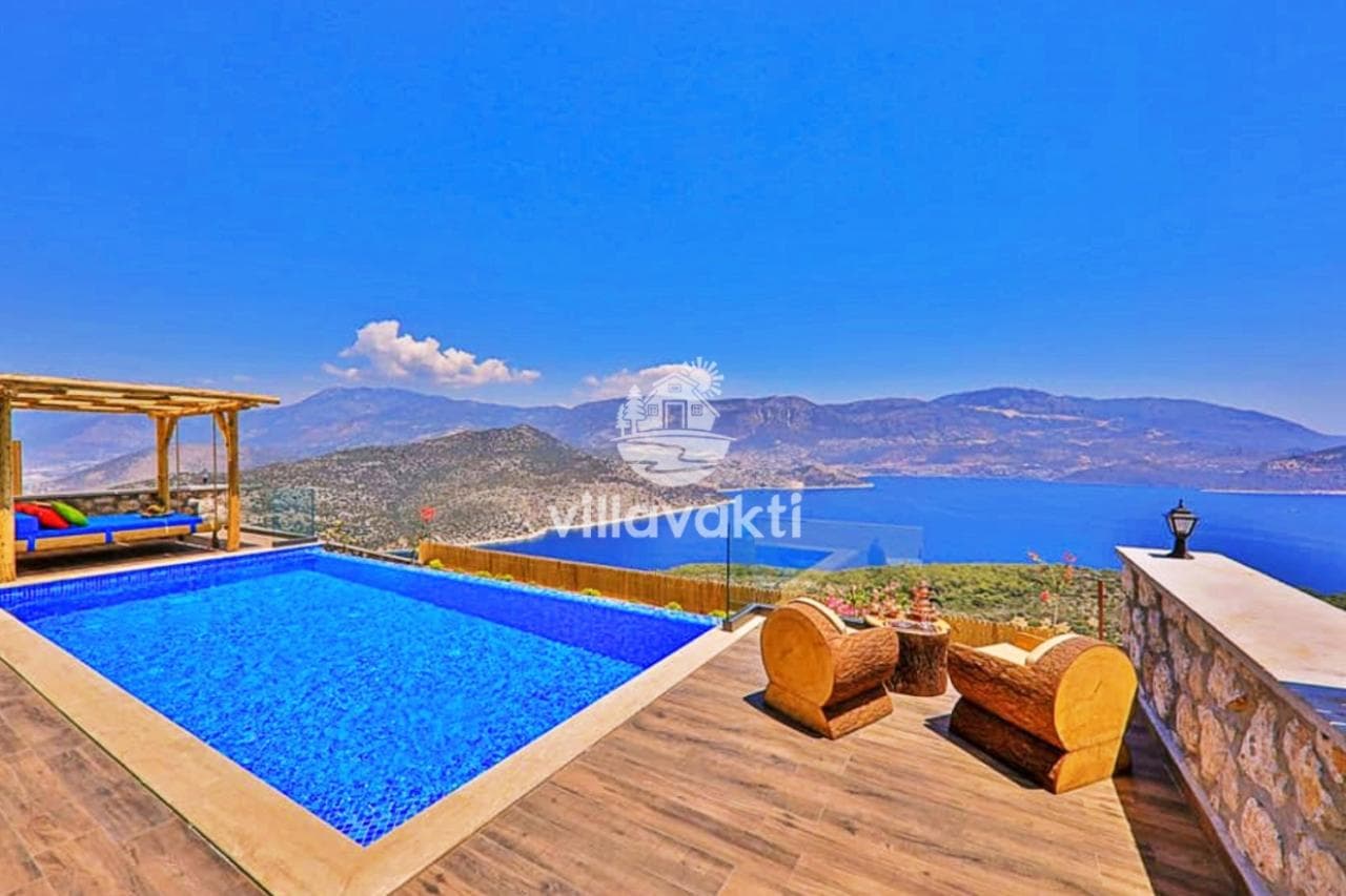 Mavi havuz kenarında ahşap şezlonglar ve deniz manzarası.