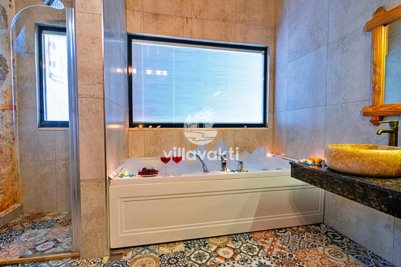 Pencereli jakuzi küveti bulunan, seramik kaplı banyo iç mekânı.