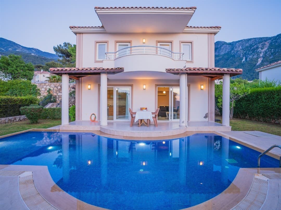 Önünde havuz bulunan, balkonlu ve bahçeli iki katlı müstakil villa.