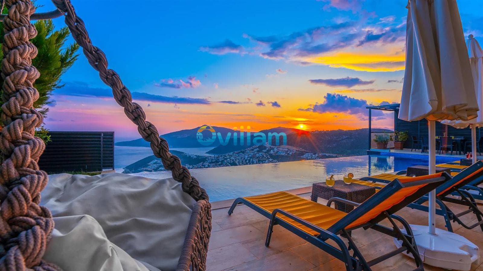 Gün batımında sonsuzluk havuzu kenarındaki şezlonglar ve asma salıncak.