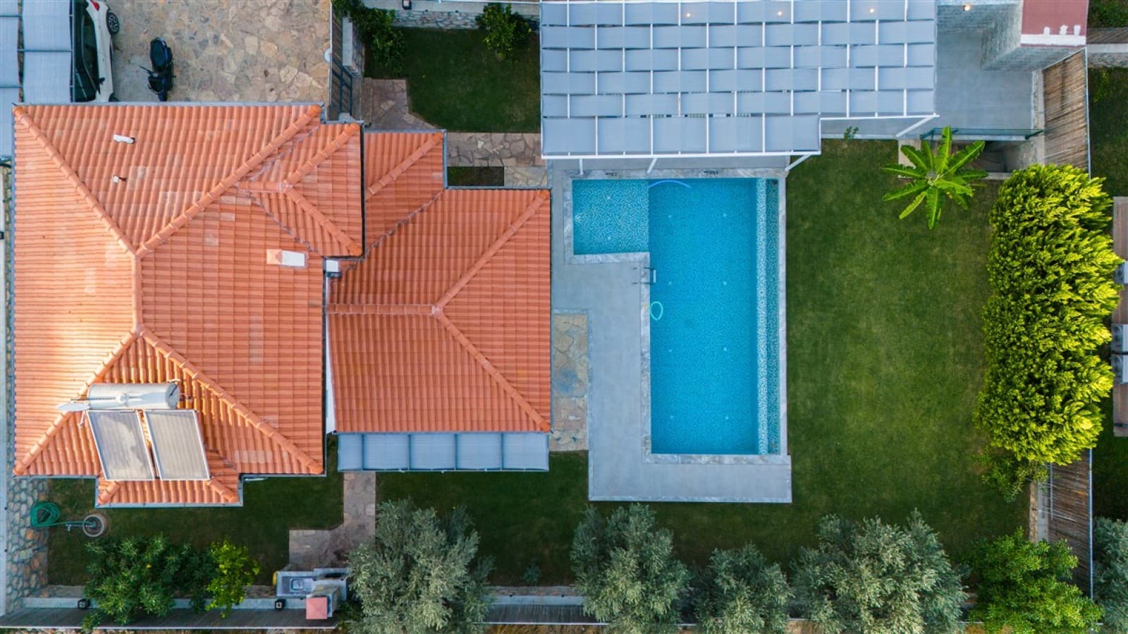 Havuz ve kiremit çatılı evin dronla yukarıdan çekilen görüntüsü