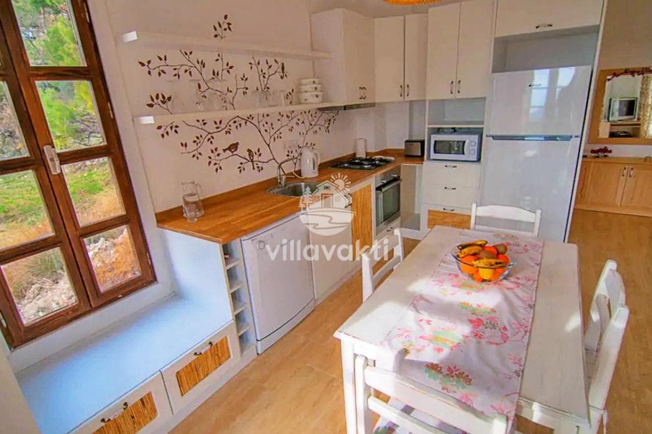 Ahşap detaylı mutfak ve önünde yemek masası.