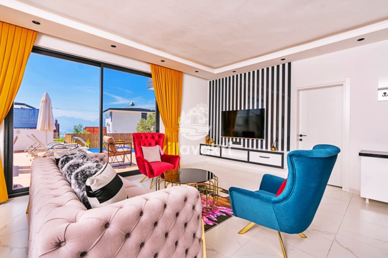 Sarı perdeli geniş pencereli, renkli berjer ve koltukların bulunduğu modern oturma odası.