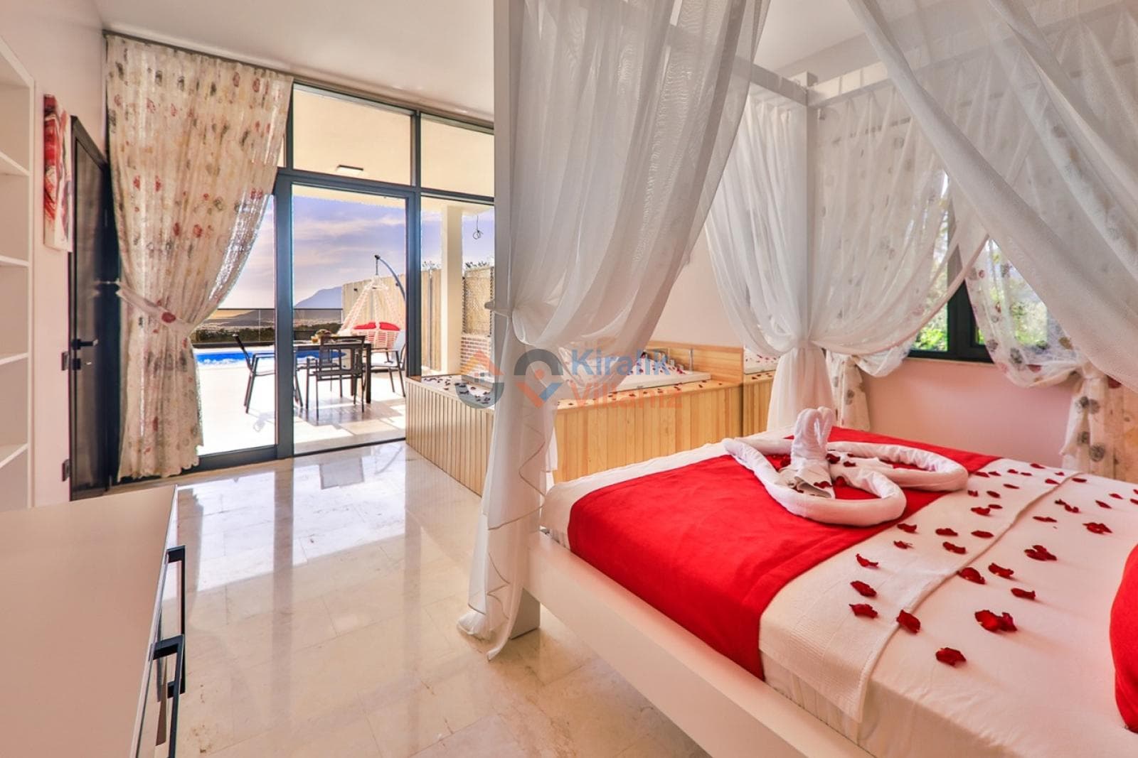 Kırmızı yatak örtülü tüllü yatak, jakuzi ve havuz manzaralı cam balkon.