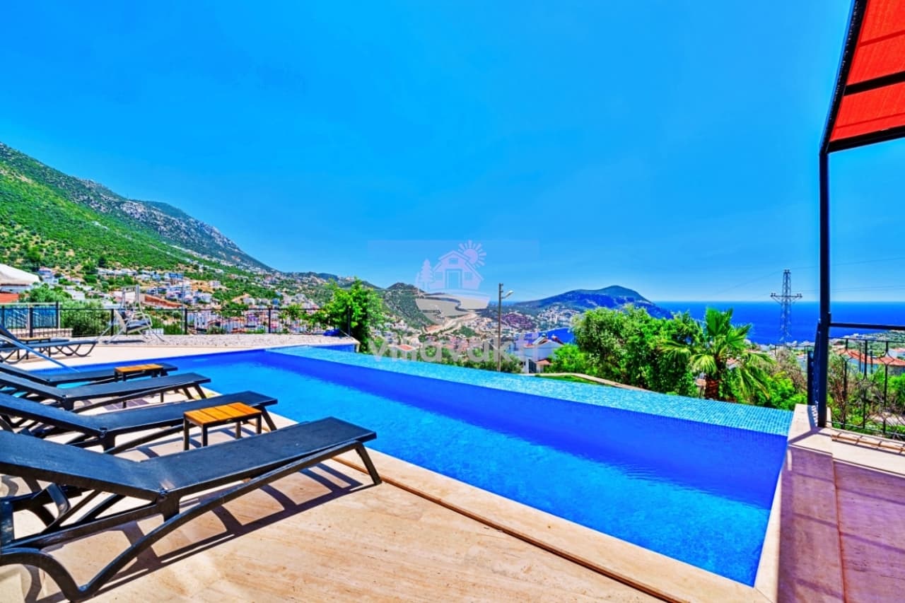 Sonsuzluk havuzu ve şezlonglar önünde doğa ile deniz manzarası