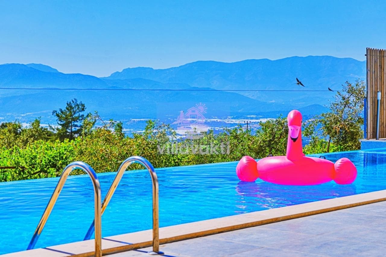 Havuzda pembe şişme flamingo ve dağ manzarası