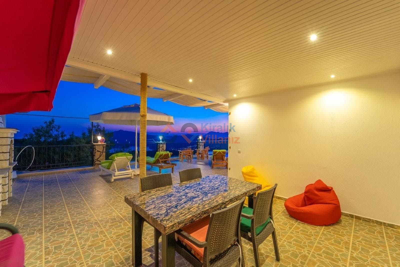 Akşam üzeri aydınlatmalı veranda ve yemek masası.