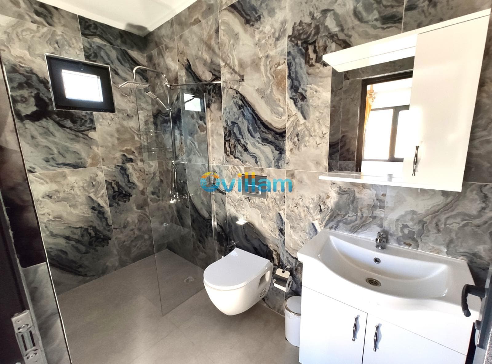 Mavi mermer kaplı duvarları olan duşakabinli modern banyo