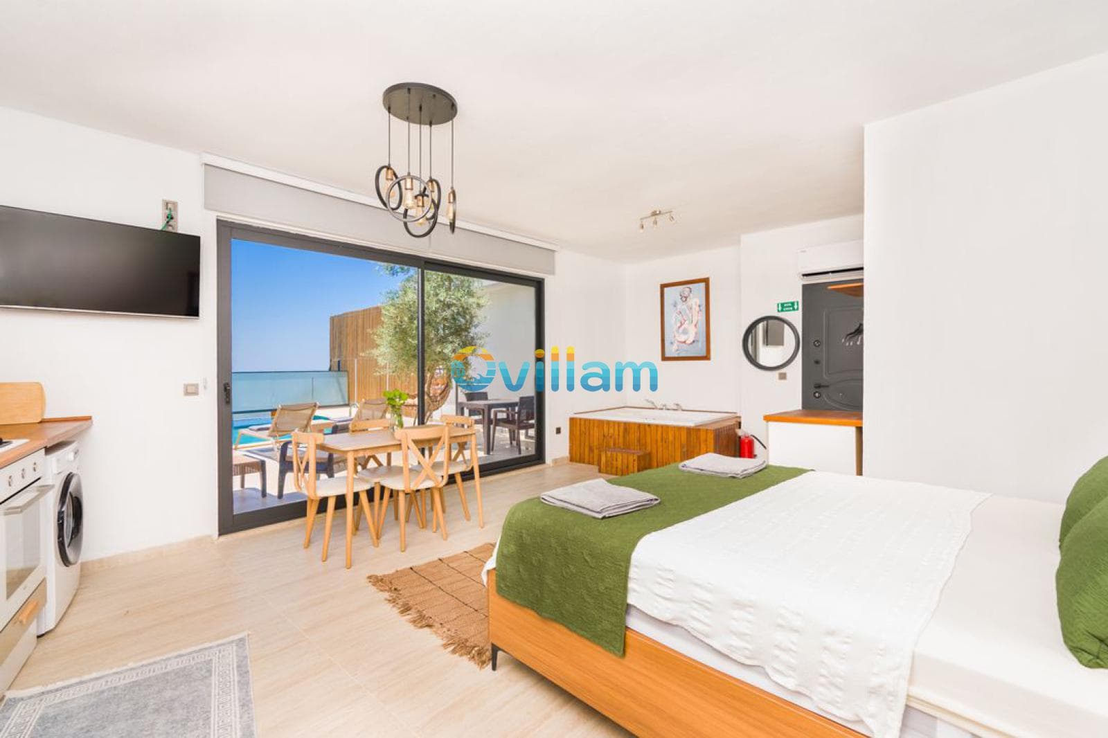 Çift kişilik yatak, jakuzi ve balkon kapısı bulunan yatak odası.