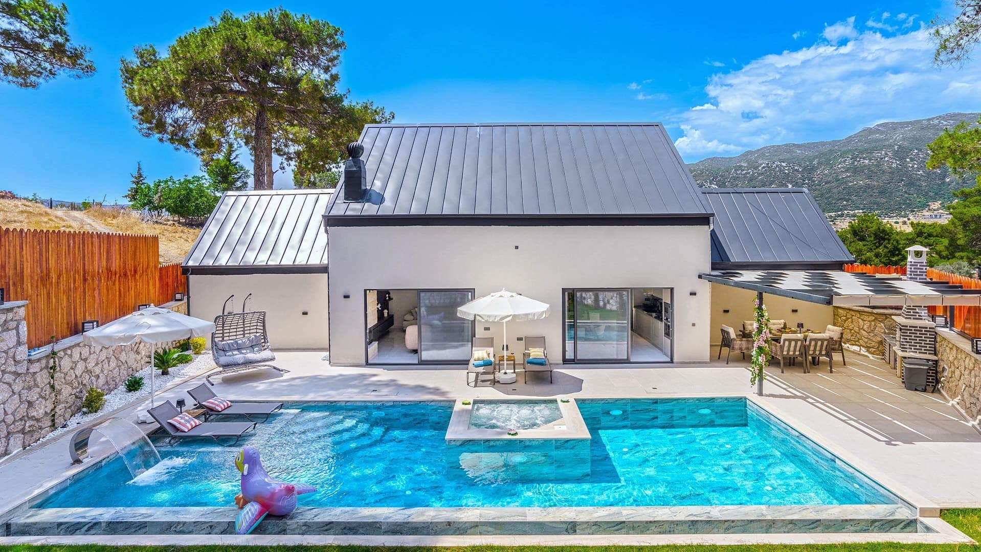 Jakuzili havuzu, şezlongları ve ağaçlı bahçesi olan modern villa