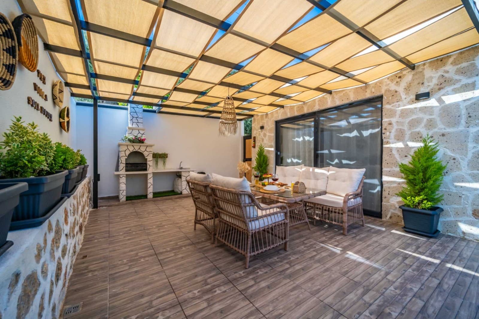 Ahşap yemek masası ve taş duvarlı veranda oturma alanı
