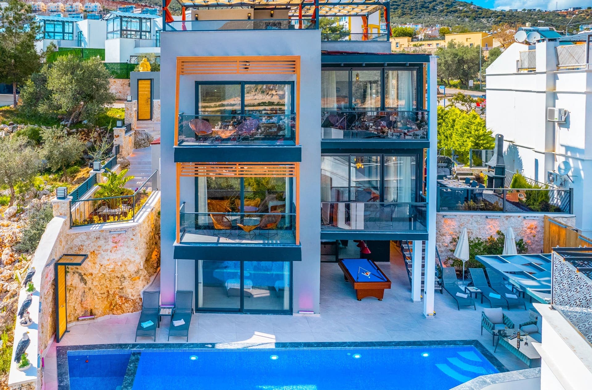 Önünde havuz bulunan modern villanın dış cephesi.