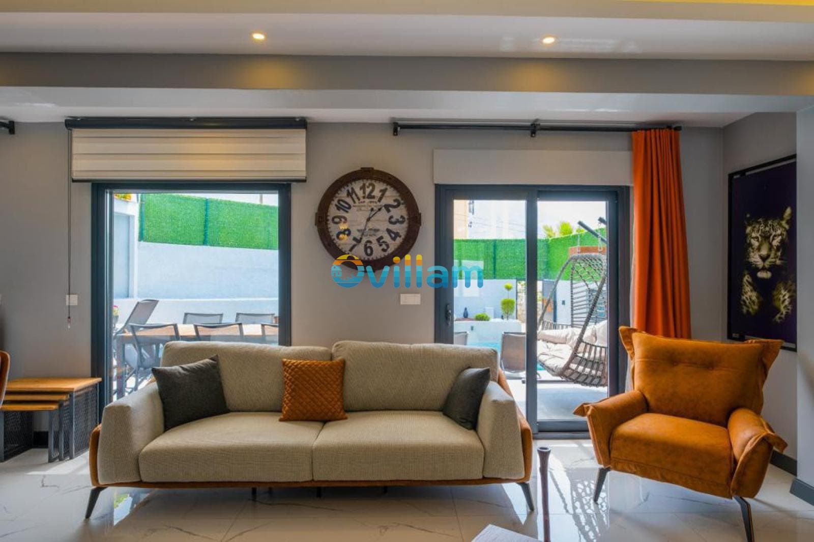 Oturma grubunun ve pencerelerin yer aldığı salon iç mekânı.