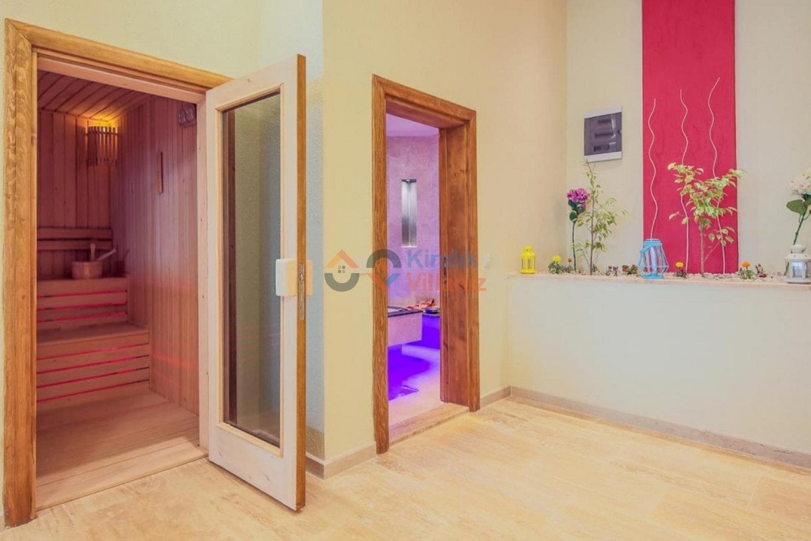 Açık renkli antrede ahşap kapılı bir sauna ve diğer odalara açılan kapılar var.