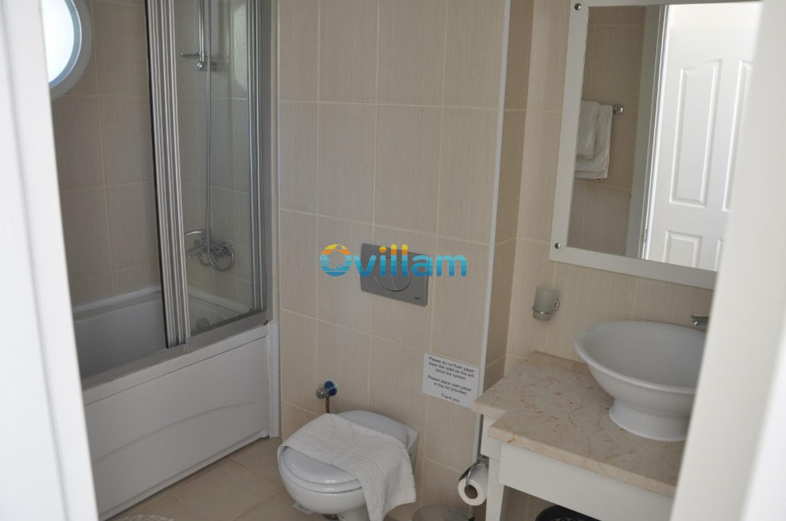 Beyaz seramikli, duşakabinli ve lavabolu banyo.