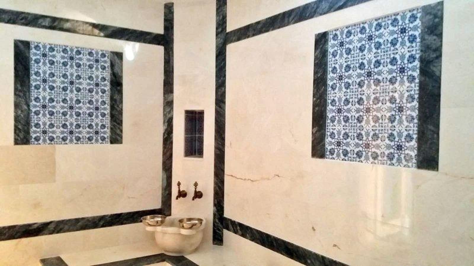 Mavi beyaz çini işlemeli mermer duvarları olan geleneksel hamam köşesi.