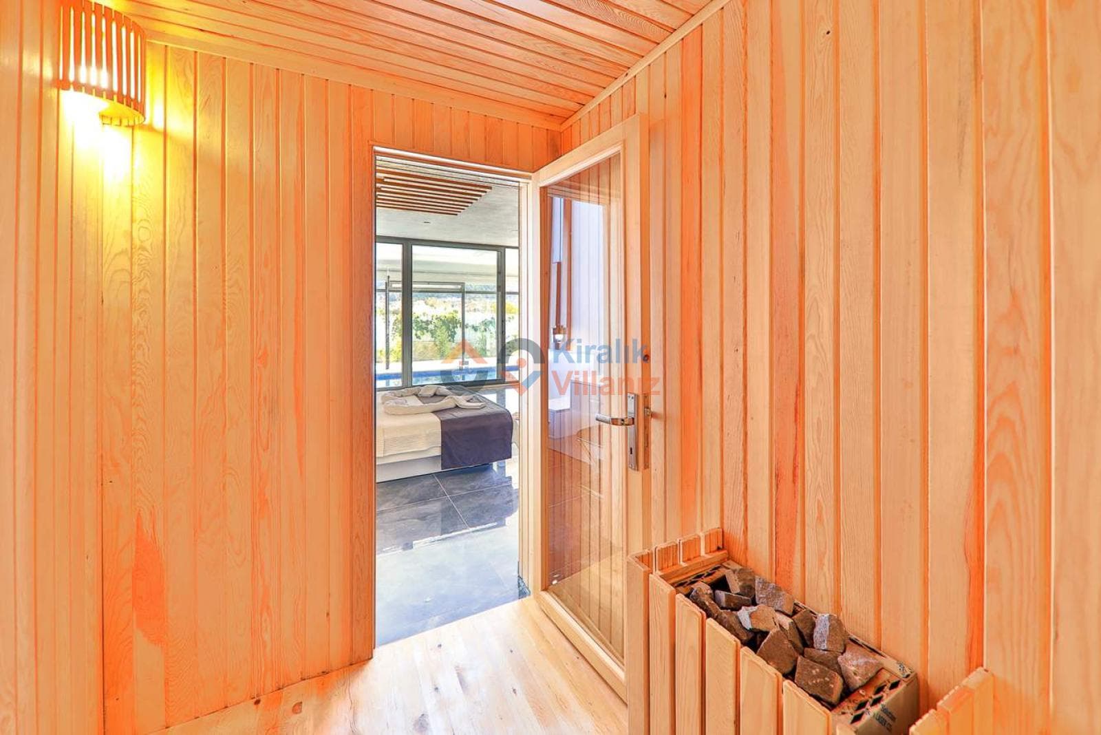 Ahşap kaplamalı sauna odası ve içeriden görünen yatak odası.
