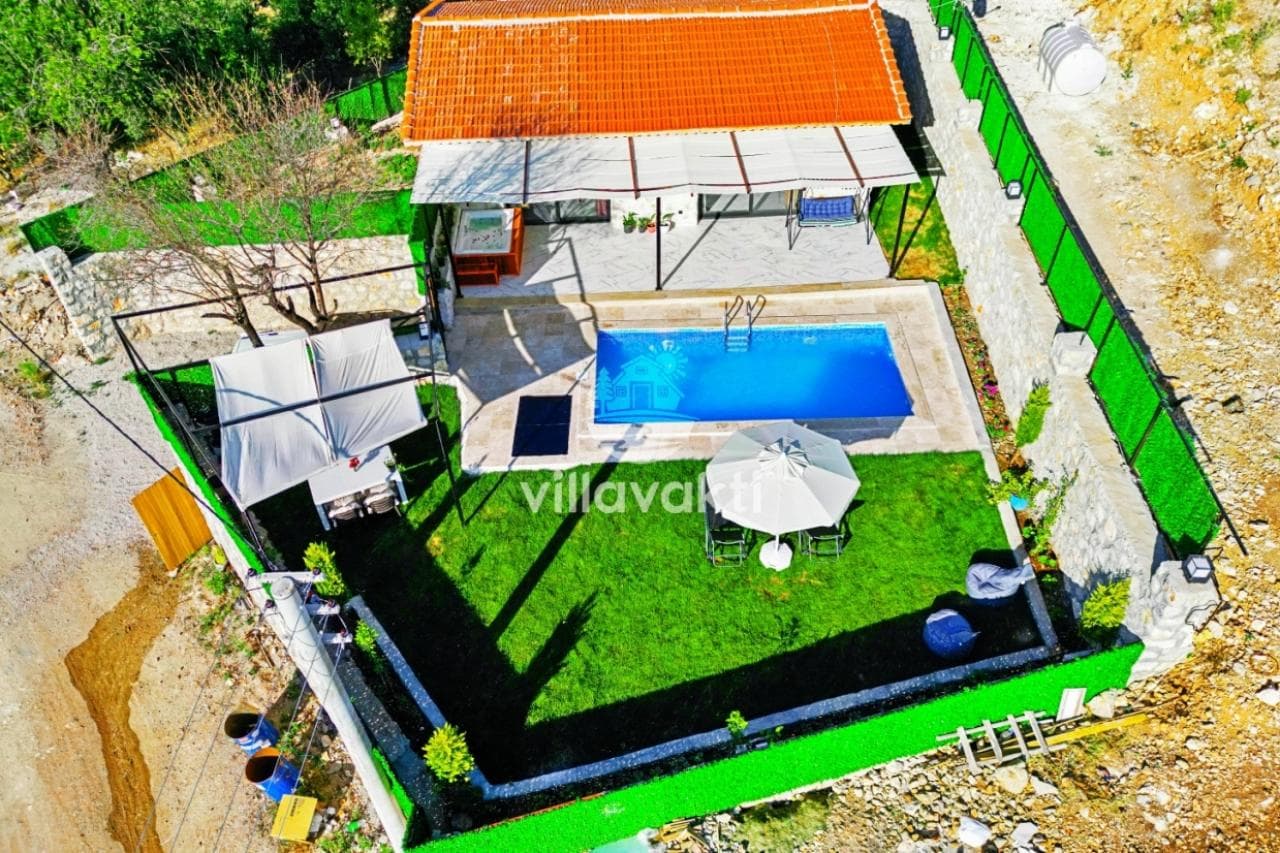 Kiremit çatılı villa, özel havuz, çim alan, şemsiye ve jakuzi içeren bahçe.
