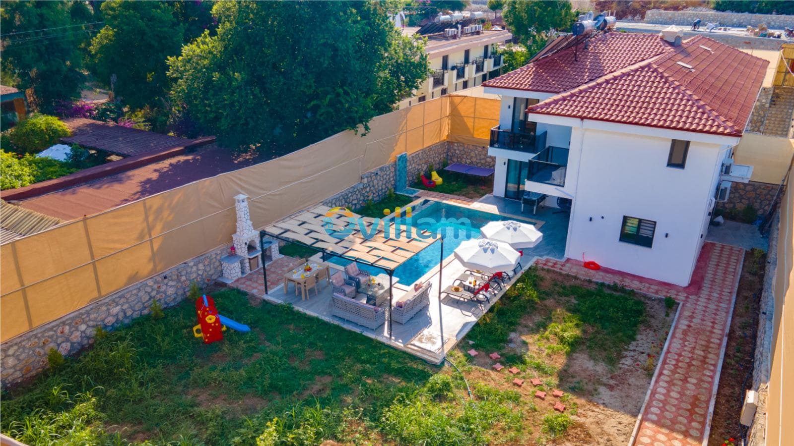Bahçesinde havuz, oturma grubu, şemsiyeler ve barbekü alanı bulunan iki katlı villa.
