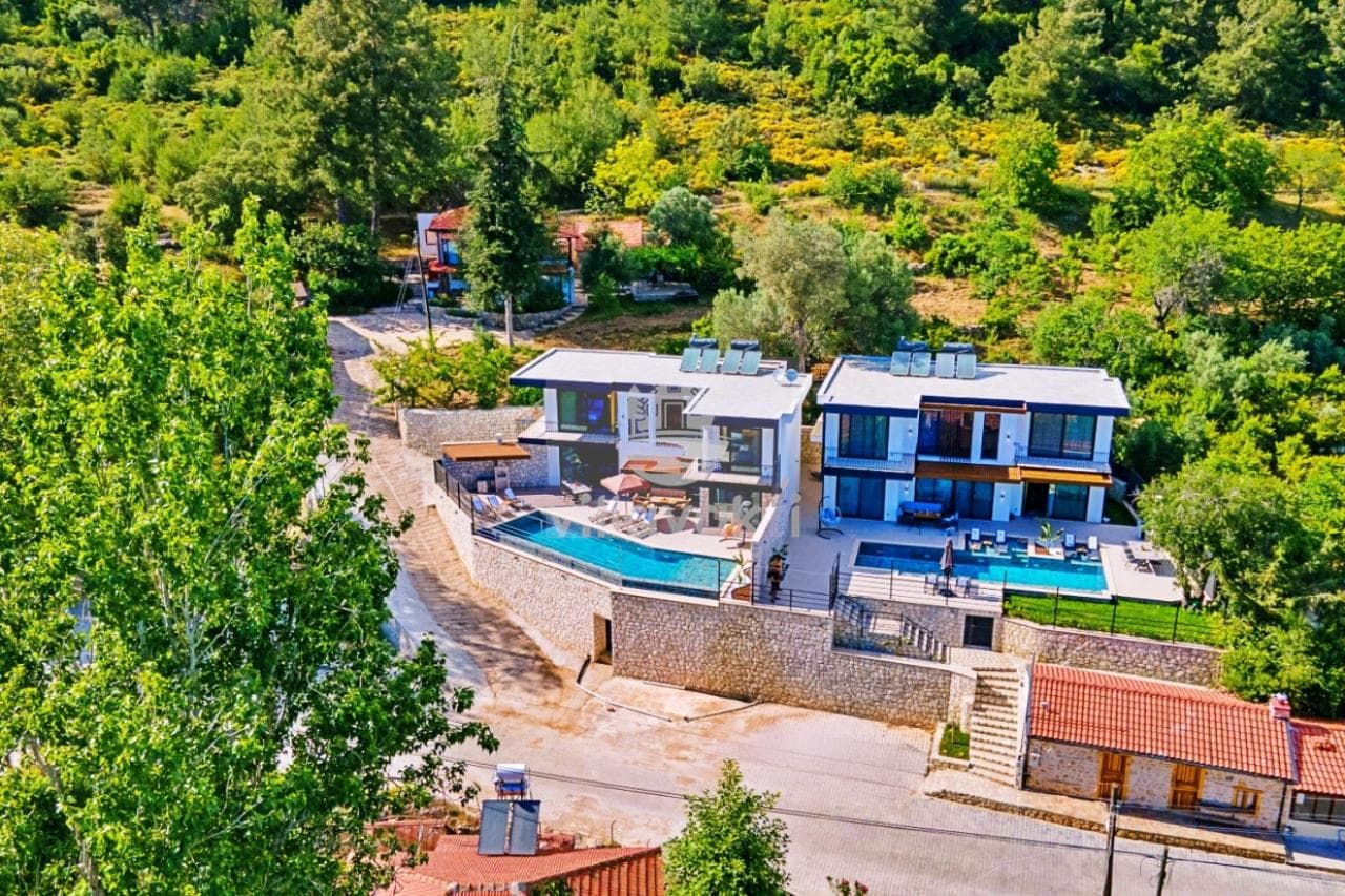 Ağaçlık yamaçta konumlanmış, özel havuzlu ve teraslı iki bitişik villa yapısı.
