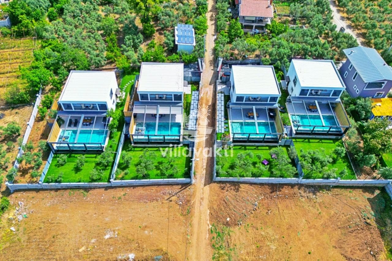 Kuş bakışı görünümde yan yana dizilmiş, özel havuzlu ve bahçeli dört adet modern villa.