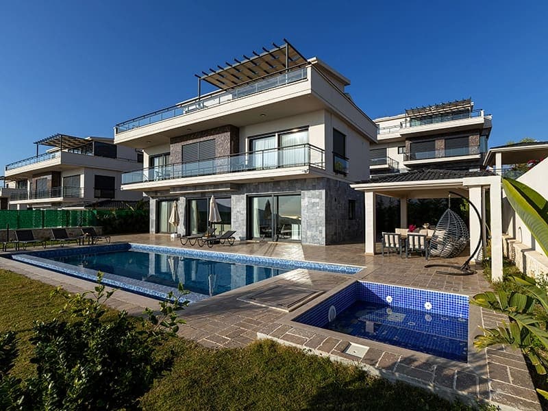 Modern villa, özel havuz, jakuzi, şezlonglar ve bahçe alanı.