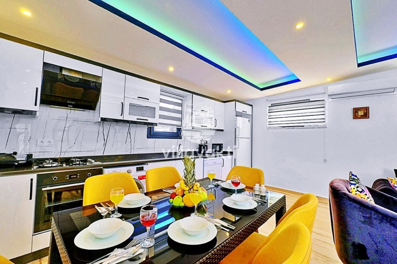 Sarı sandalyeli yemek masası ve beyaz dolaplı modern mutfak.