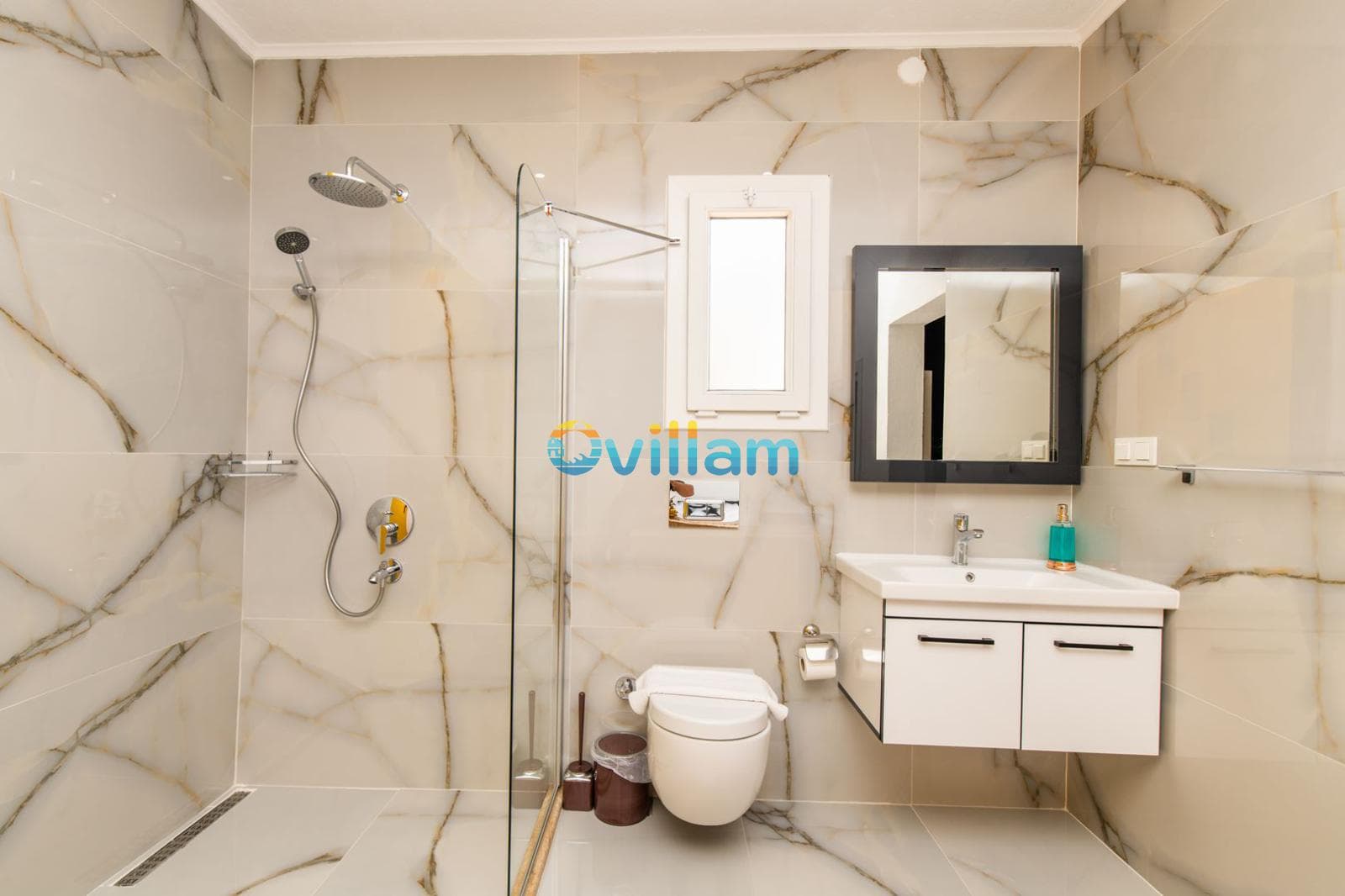 Mermer desenli duvarlara sahip, duşakabinli, beyaz lavabo dolaplı ve klozetli modern banyo.