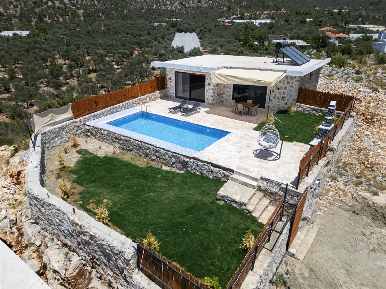 Zeytin ağaçlarıyla çevrili dağ yamacında, özel yüzme havuzlu taş villa.