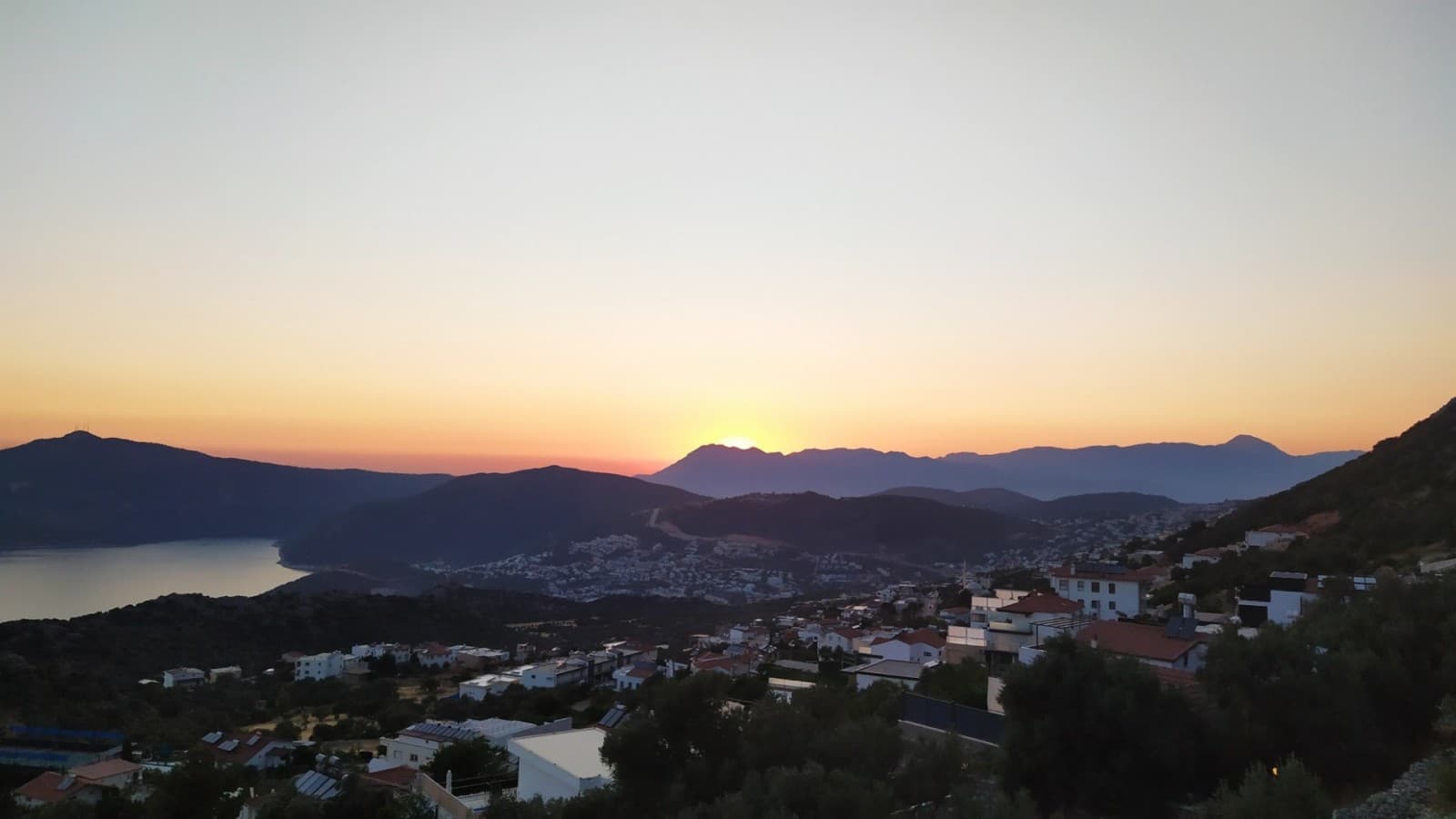 Dağların arkasından batmakta olan güneşin oluşturduğu akşam manzarası.