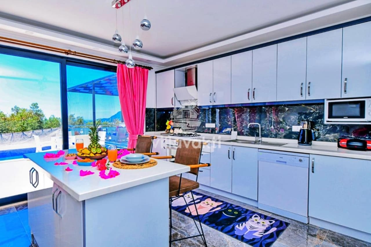 Mutfak adası, beyaz dolaplar ve üzerinde meyveler bulunan modern mutfak.
