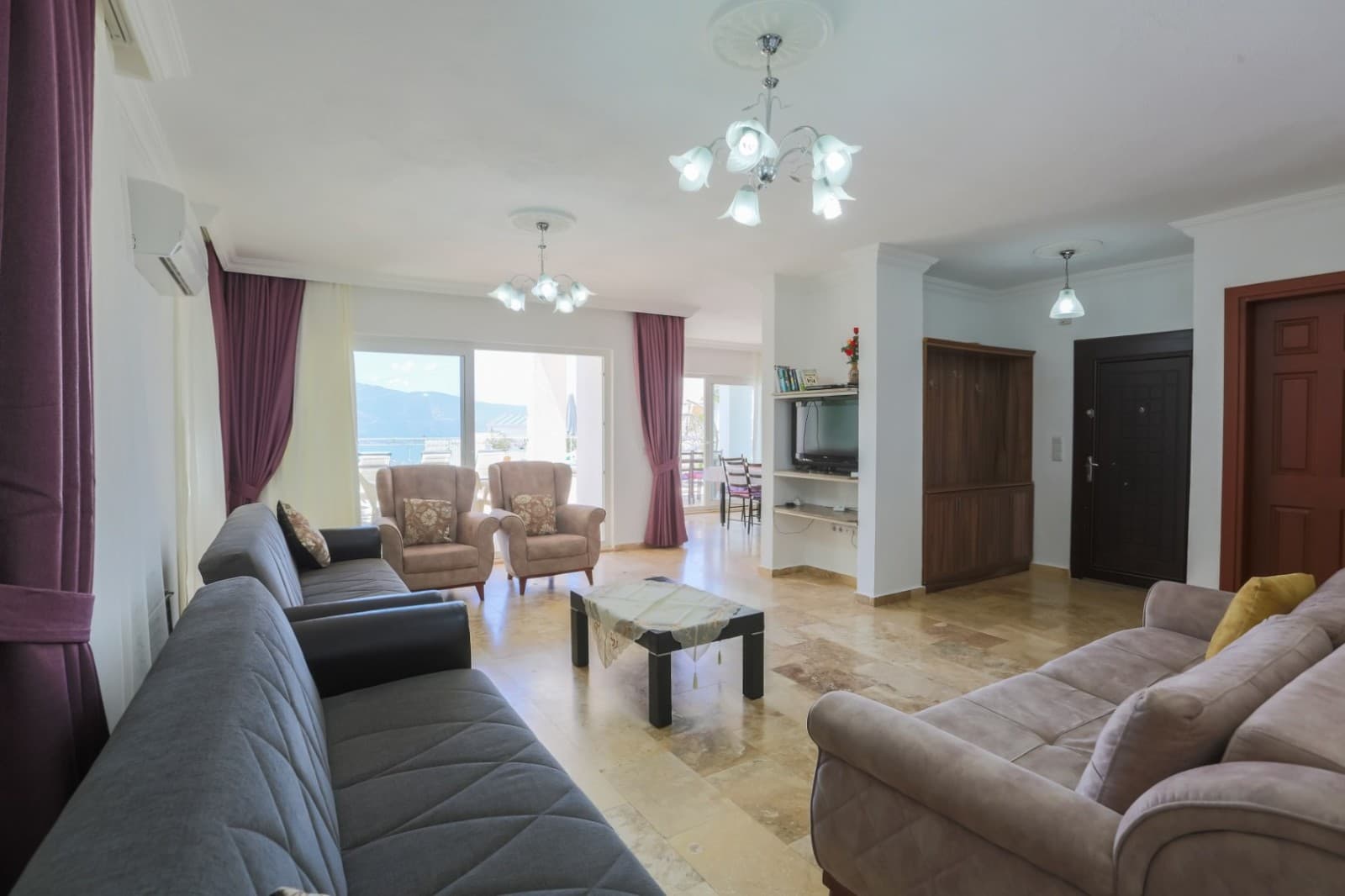 Gri koltuk takımı ve pencereli aydınlık salon.