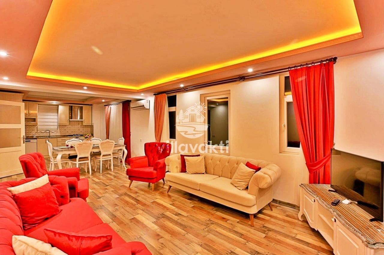 Ahşap parkeli ve renkli koltuk takımlı geniş iç mekân.
