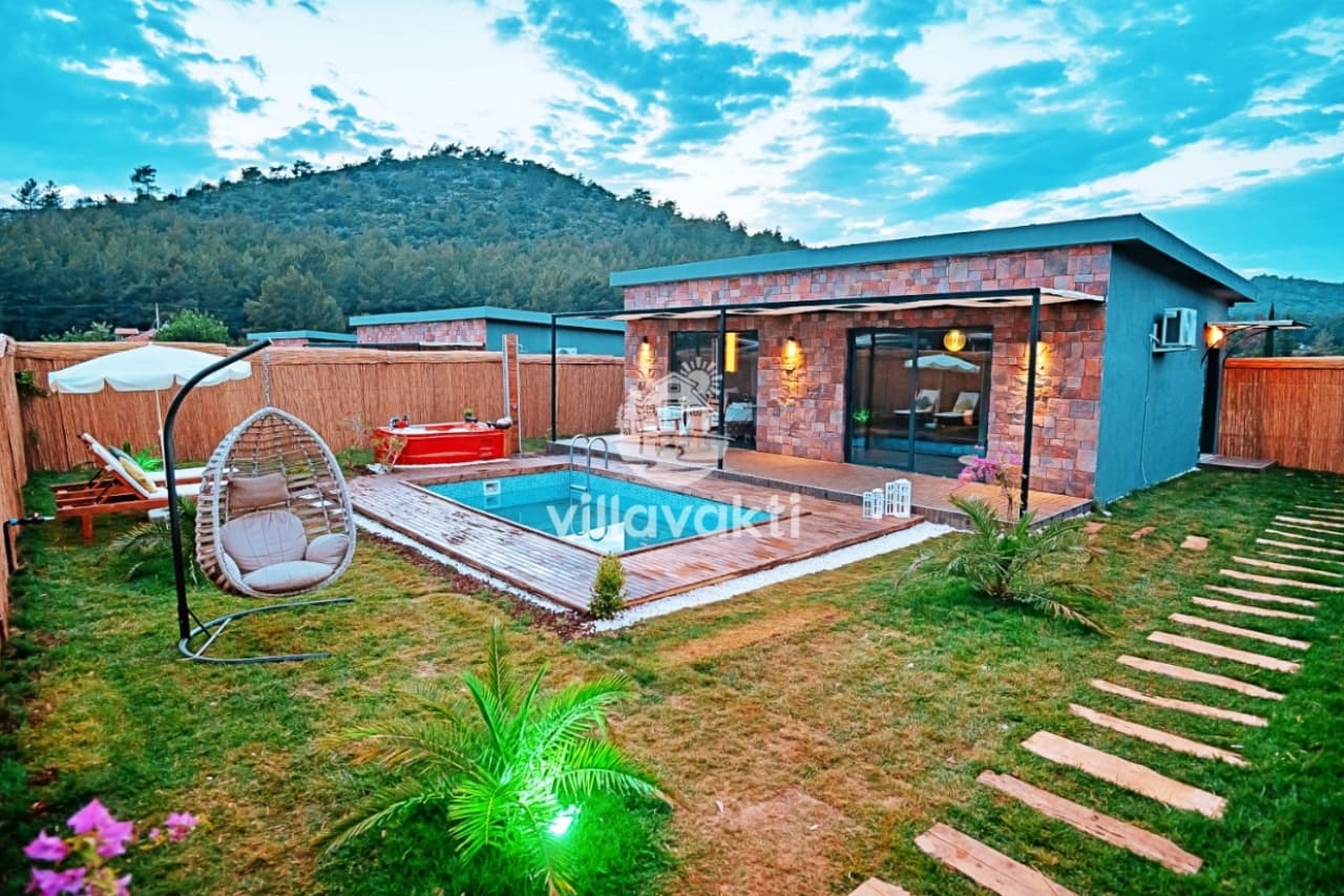 Bahçesinde havuz ve salıncak bulunan tek katlı taş villa.